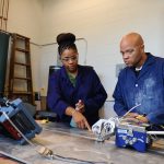 Two engineers work at a table.