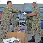 Sailors from Expeditionary Medical Facility-M collect their personal protective equipment near the New Orleans Convention Center, April 6, 2021.